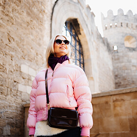 Woman in pink jacket near fortress walls in Icherisheher Old City Baku
